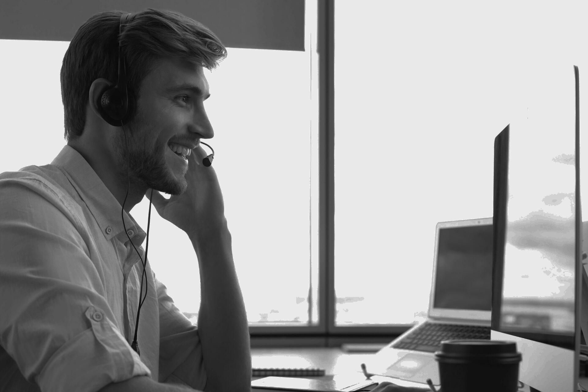 homme souriant au travail avec un casque téléphonique professionnel passant des appels