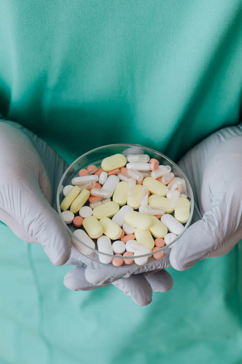 un pharmacien tenant dans sa main des comprimés et pilules médicamenteuses